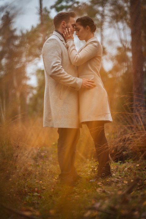 Paar Umarmung auf Waldwiese mit Gras im Vordergrund