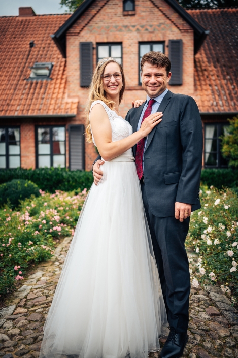 Brautpaarshooting vor Fachwerkhaus im Arm haltend