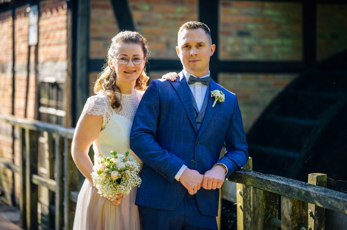 Brautpaar auf Brücke Mühlrad im Hintergrund