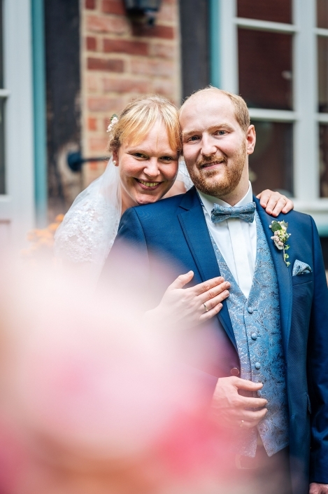 Brautpaar Portrait unschwarfer Blumenstrauß im Vordergrund Fachwerk im Hintergrund