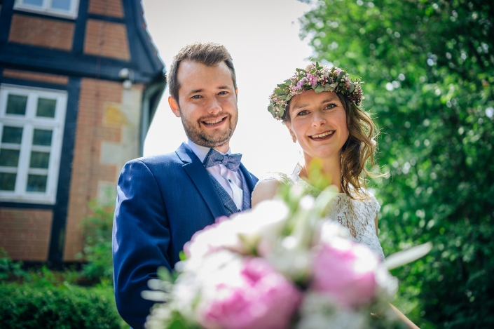 Brautpaarshooting Portrait mit Fachwerkhintergrund Brautstrauß unscharf